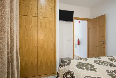 a bedroom with a large wooden cabinet and a bed at Enxurros House in Ponta Delgada