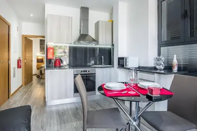 a small kitchen with a table with a red table cloth at Enxurros House in Ponta Delgada
