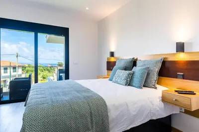 a bedroom with a bed with a view of the ocean at Enxurros House in Ponta Delgada