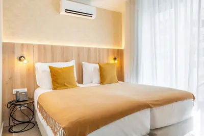 a hotel room with a large bed with yellow pillows at Vila Baleira Residence in Funchal