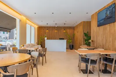 a restaurant with wooden tables and chairs and a whiteboard at Vila Baleira Residence in Funchal