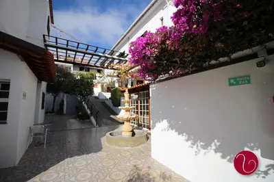 a courtyard with purple flowers on a building at GuestHouse Vila Lusitania in Funchal