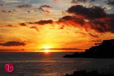 a sunset over the ocean with the sun setting at GuestHouse Vila Lusitania in Funchal