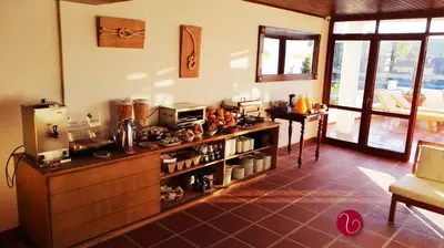 a kitchen with a counter with a microwave and a table at GuestHouse Vila Lusitania in Funchal