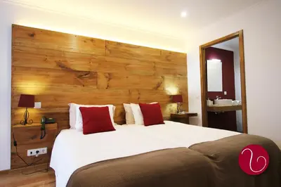 a bedroom with a large bed with a wooden headboard at GuestHouse Vila Lusitania in Funchal