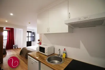 a kitchen with a sink and a microwave on a counter at GuestHouse Vila Lusitania in Funchal