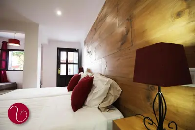 a bedroom with a bed with a large wooden headboard at GuestHouse Vila Lusitania in Funchal