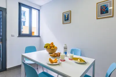 a dining room with a white table and blue chairs at The Bay View - by LovelyStay in Funchal
