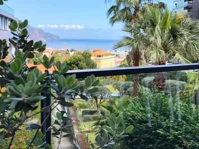 a balcony with a view of the ocean and palm trees at The Bay View - by LovelyStay in Funchal