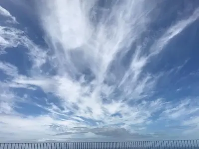 a cloudy sky with a fence in the foreground at Endless Blue House in Arco da Calheta