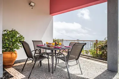 a patio with a table and chairs on a balcony at Vivenda da Natureza in Santa Cruz