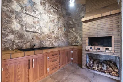 a kitchen with a stone wall and a fireplace at Vivenda da Natureza in Santa Cruz