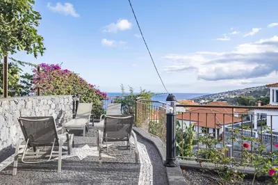 a balcony with chairs and a view of the ocean at Vivenda da Natureza in Santa Cruz