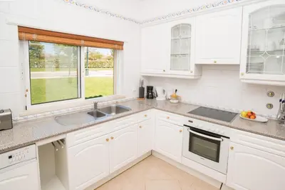 a kitchen with white cabinets and a window at Boavista Fairviews Village in Lagos