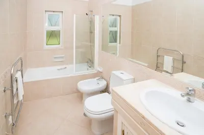 a bathroom with a toilet and a sink and a mirror at Boavista Fairviews Village in Lagos