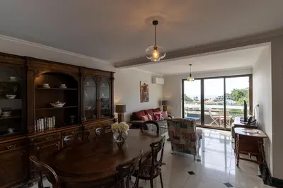 a living room with a wooden table and a dining room at Magnolia Apartment Luxury Apt Great views in Funchal