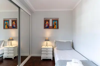 a white bedroom with a bed and two night stands at Magnolia Apartment Luxury Apt Great views in Funchal
