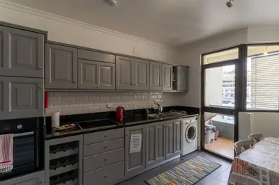 a kitchen with gray cabinets and a washer and dryer at Magnolia Apartment Luxury Apt Great views in Funchal