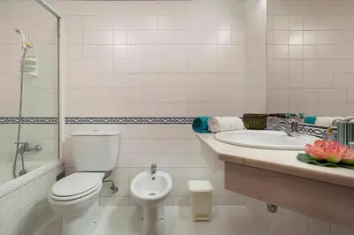 a white bathroom with a toilet and a sink at Apartment Bay Historic Center in Funchal