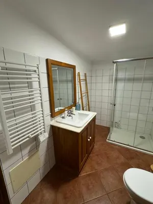a bathroom with a sink and a mirror and a shower at Casa dos Reis in Calheta