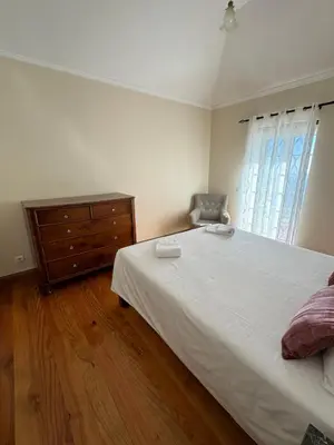 a bedroom with a bed and a dresser and a window at Casa dos Reis in Calheta