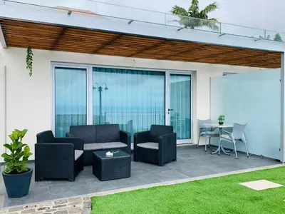 a patio with chairs and a table and glass doors at Casa dos Reis in Calheta