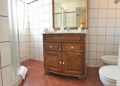 a bathroom with a sink and a mirror and a toilet at Casa dos Reis in Calheta