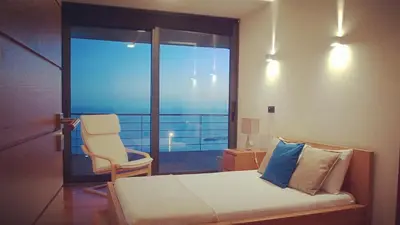 a bedroom with a bed and a chair and a window at Villa Cary in Funchal
