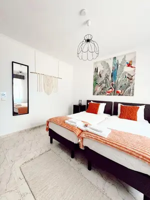a bedroom with a large bed and a chandelier at Gardens Guest House in São Vicente
