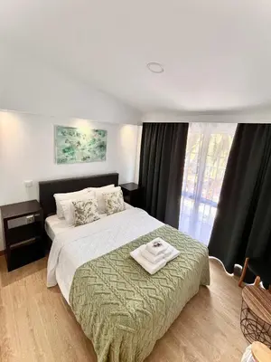 a hotel room with a bed with a towel on it at Gardens Guest House in São Vicente
