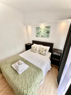 a bedroom with a bed with a towel on it at Gardens Guest House in São Vicente