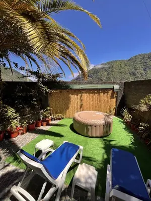 a yard with two chairs and a fire pit at Gardens Guest House in São Vicente