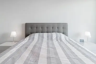 a bedroom with a large bed with two lamps at Apartamento Monumental - By WeHost Madeira in Funchal