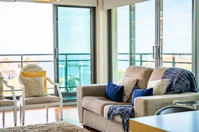 a living room with a couch and chairs and windows at Apartamento Monumental - By WeHost Madeira in Funchal