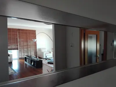 a bottle of wine and two glasses on a balcony at Zen Caniço Apartment in Caniço