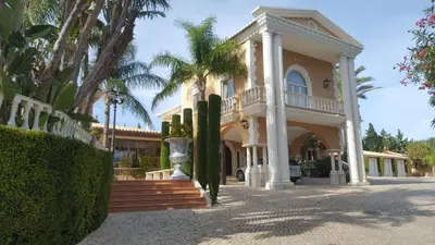 a large house with palm trees in front of it at Resort Fazenda Viegas in Lagos