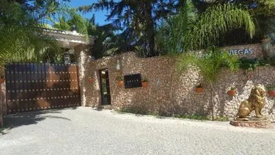 a stone building with a gate and a fence at Resort Fazenda Viegas in Lagos