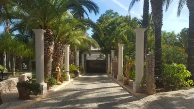 a gate to a villa with palm trees at Resort Fazenda Viegas in Lagos
