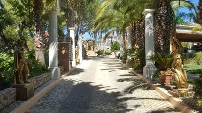 a walkway in a resort with palm trees at Resort Fazenda Viegas in Lagos