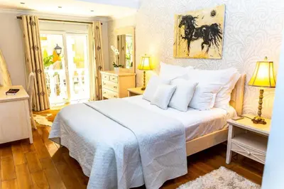 a bedroom with a white bed with a horse painting on the wall at Resort Fazenda Viegas in Lagos