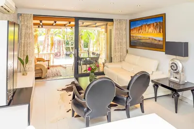 a living room with a couch and a table and chairs at Resort Fazenda Viegas in Lagos