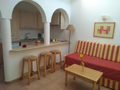 a living room with a couch and a kitchen at Club House CVL in Luz