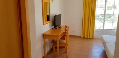 a room with a desk with a computer and a television at Club House CVL in Luz