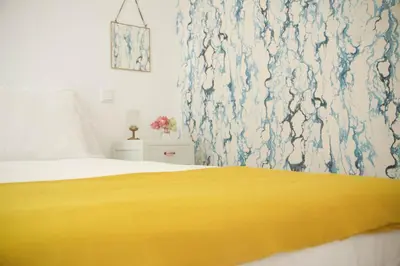 a bedroom with a yellow blanket on a bed at Irlandas Villa Funchal Seaside Villas in Funchal
