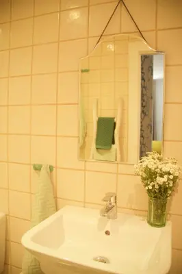 a bathroom with a sink and a mirror and flowers at Irlandas Villa Funchal Seaside Villas in Funchal