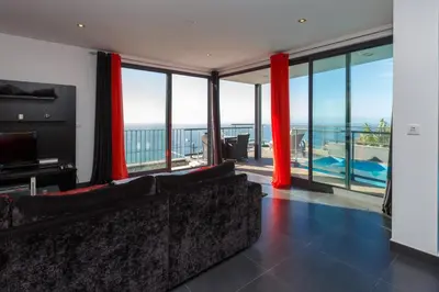 a living room with a couch and a view of the ocean at Villa Maciel in Calheta
