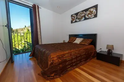 a bedroom with a bed and a large window at Villa Maciel in Calheta