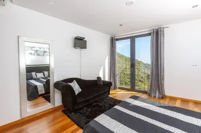 a living room with a couch and a large window at Villa Maciel in Calheta