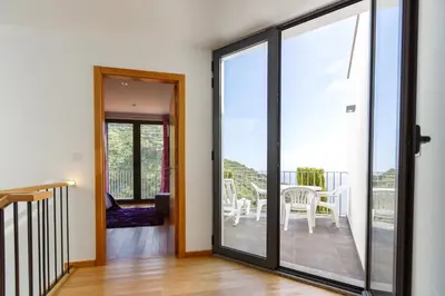 a sliding glass door leading to a balcony with a table and chairs at Villa Maciel in Calheta