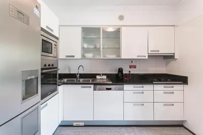 a white kitchen with white cabinets and a sink at Costa Sol IX by Madeira Holiday Rentals in Funchal
